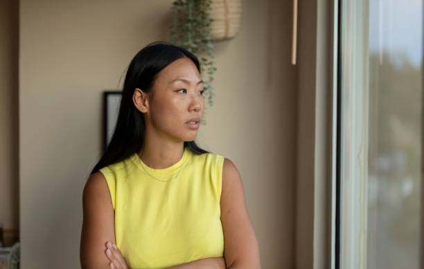 istock Thoughtful Young Woman Looking Out the Window 2159464446