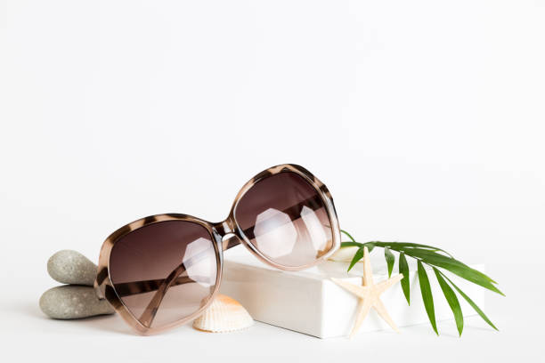 istock sunglasses with seashell lying on table background. Sunglasses on summer background. Top view flat lay with copy space for text 2159465931
