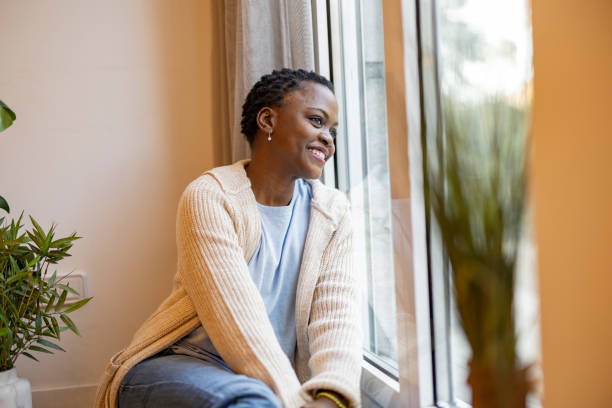 istock Young Woman Smiling and Looking Out the Window 2159466775