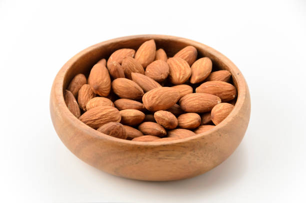 istock unglazed almonds in a Wooden round bowl on a white background 2159472644