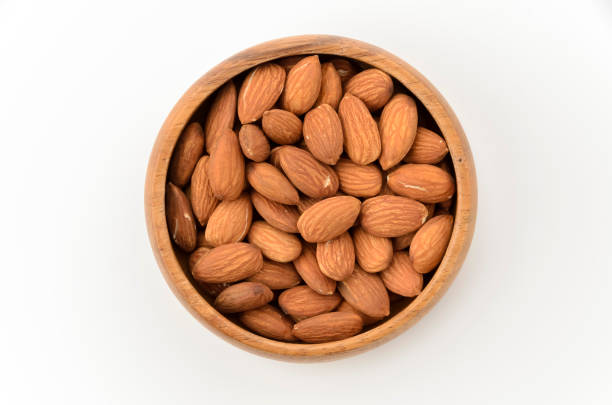 istock unglazed almonds in a Wooden round bowl on a white background 2159472653