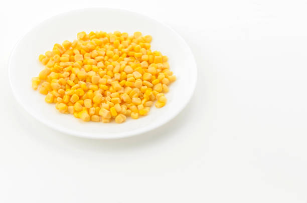 Canned sweet corn on a white plate on white background