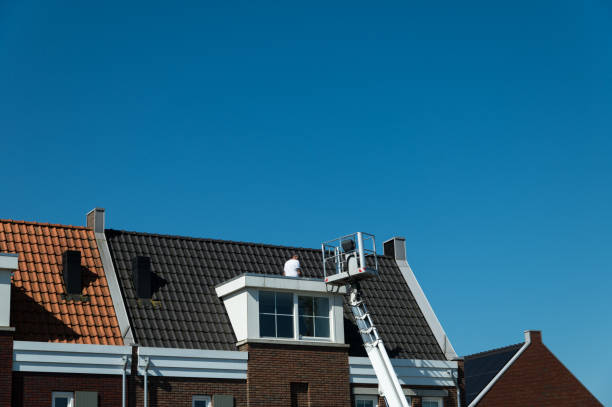 2024 06 26 Harderwijk, Netherlands: A man is working on a dormer window of a new-build house. Part of a white aerial platform is visible on the right. In the background a deep blue sky.