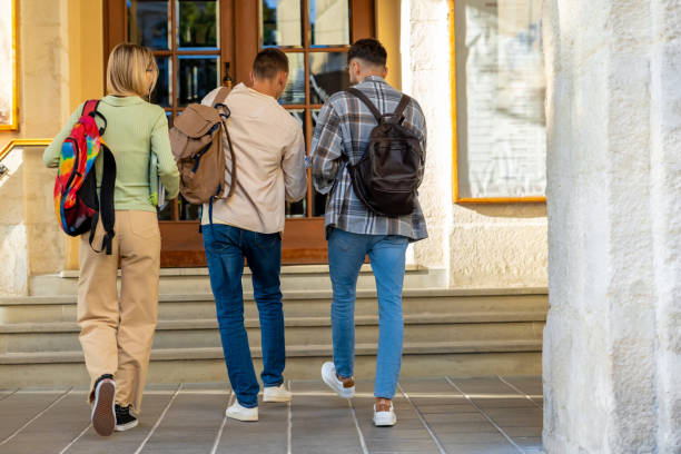 istock Back view of students walking in university campus 2159479124