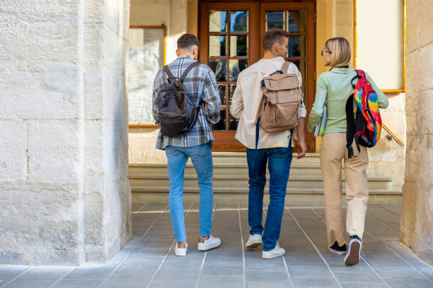 istock Back view of students walking in university campus 2159479128