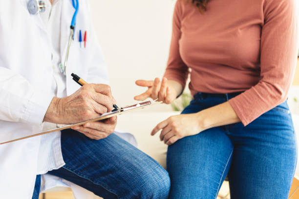 istock Senior doctor making notes while talking with female patient at medical room 2159479502