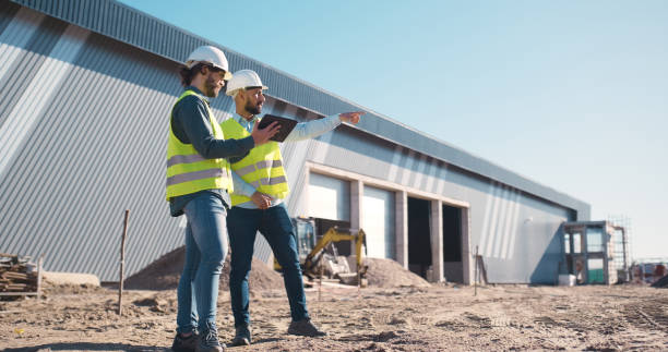 istock Planning, tablet and engineering team at outdoor construction site, warehouse and building development. Teamwork, digital survey and architecture contractor, builder or people with property vision 2159482066