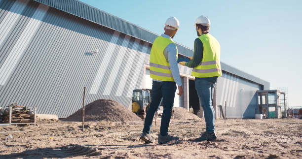 istock Construction worker, team and tablet for outdoor planning, building progress or floor plan development. Project manager or people back on digital technology for architecture, site and property design 2159482069