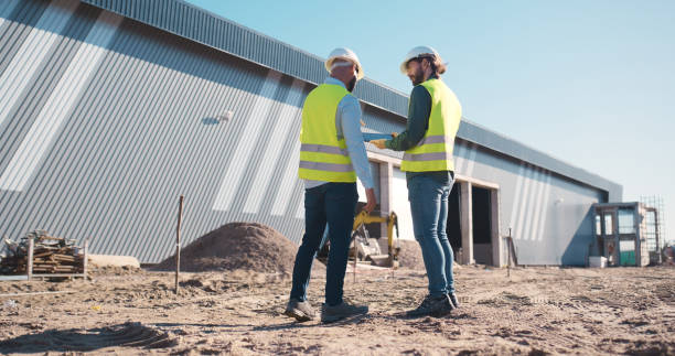 istock Construction site, tablet and engineering team, outdoor planning, building or floor plan development. Project manager or people back on digital technology for outdoor architecture and property design 2159482095
