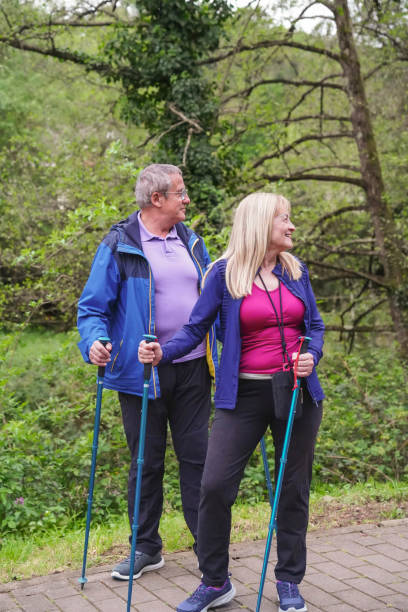 istock A man and a woman are standing in a forest, both wearing blue jackets 2159484662