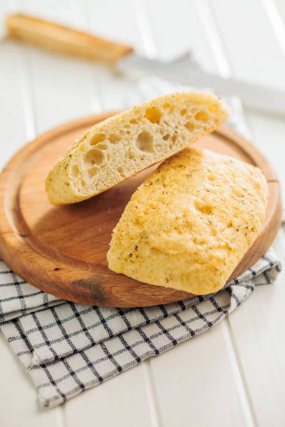istock Italian ciabatta bread on cutting board on white table. 2159487872