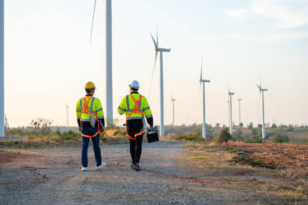istock Diverse ethnicity male technicians walking in the wind turbines field. Innovation engineer men wearing safety gear, work to develop environmental renewable clean energy outdoors at windmill power farm 2159487982