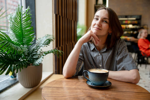 istock Smiling woman at the table in a cafe, looking at camera 2159488068