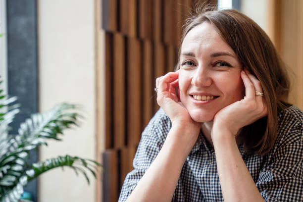 istock Smiling woman at the table in a cafe, looking at camera 2159488193