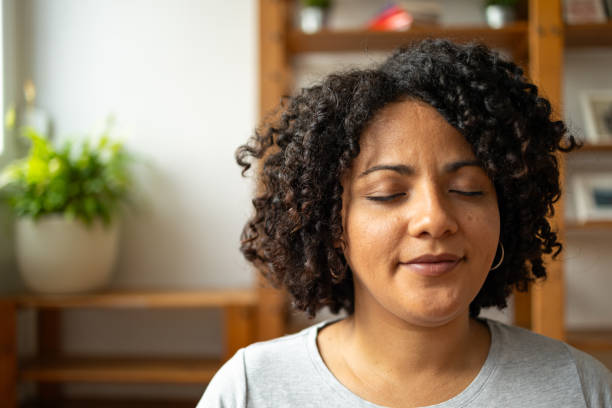 Relaxed woman smiling while meditating at home