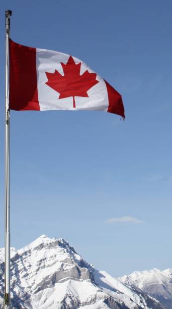 istock Canadian Flag with Snow capped peak behind 2159490961