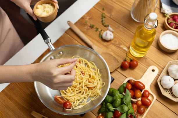 istock Close up influencer cooking spaghetti mix ingredient to frying pan. Postulate. 2159491191