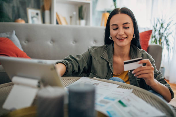 istock Smiling woman using credit card for online shopping 2159492139