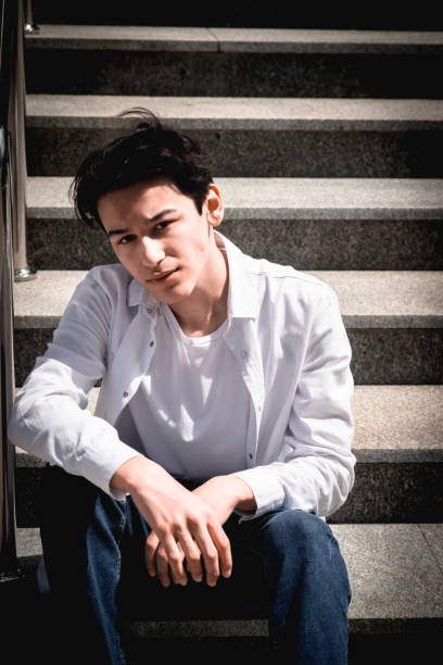 istock Handsome young man, student sits on steps in city 2159495031