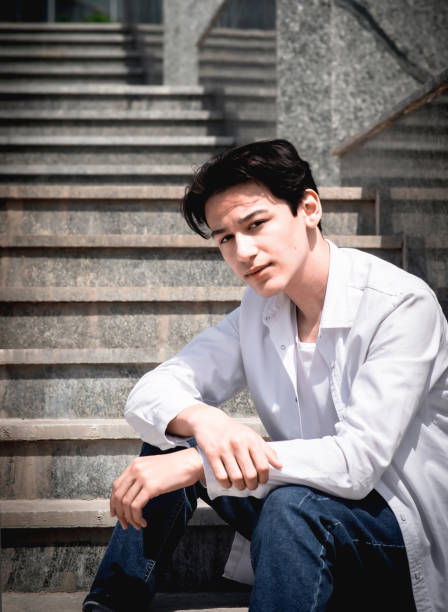 istock Handsome young man, student sits on steps in city 2159495046