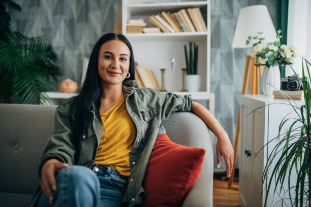 Woman relaxing on a couch with a smile, front view.