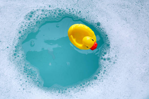 istock Yellow rubber duck in water with soap foam 2159495811
