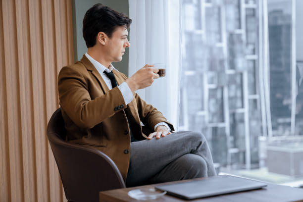 istock Smart businessman holding coffee cup while looking skyscraper view. Ornamented. 2159498380