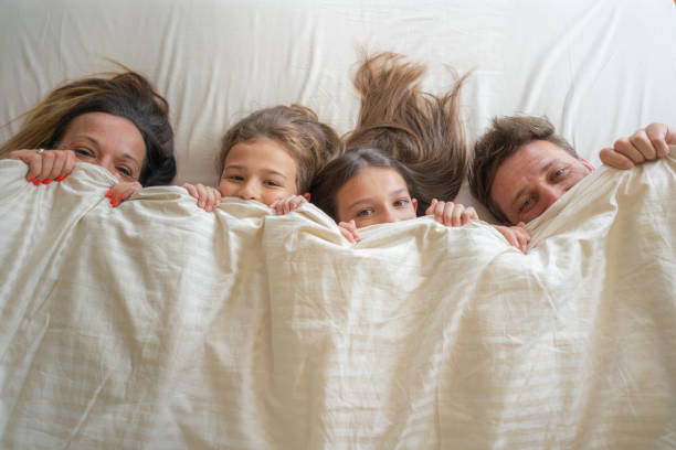 istock Family lying down in bed together at home 2159498424