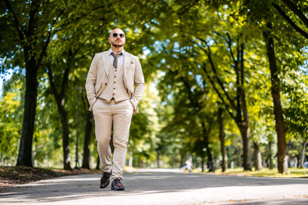 Young businessman walking in a public park outdoors.