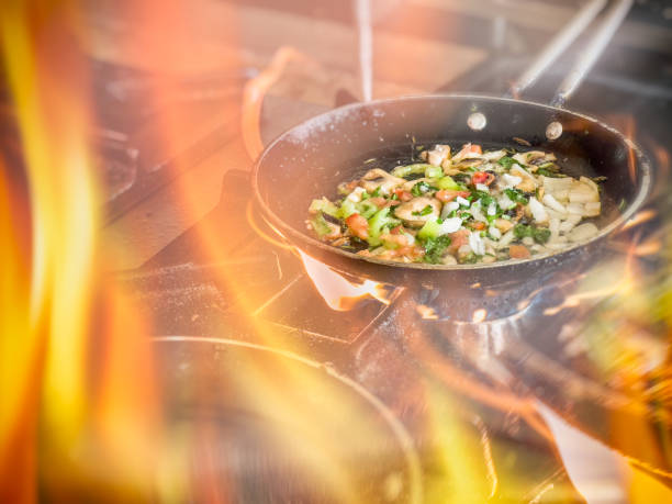 istock Cooking vegetables in frying pan with flames 2159499119