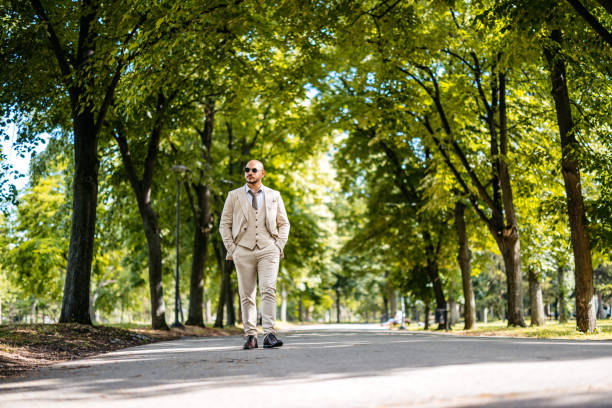 Young businessman walking in a public park outdoors.