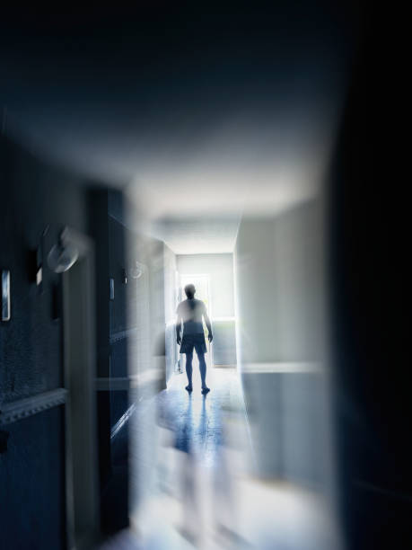 istock One man walking in narrow corridor in to glowing light 2159499744