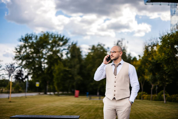 istock Young Businessman Talking On The Phone In A Public Park 2159502961