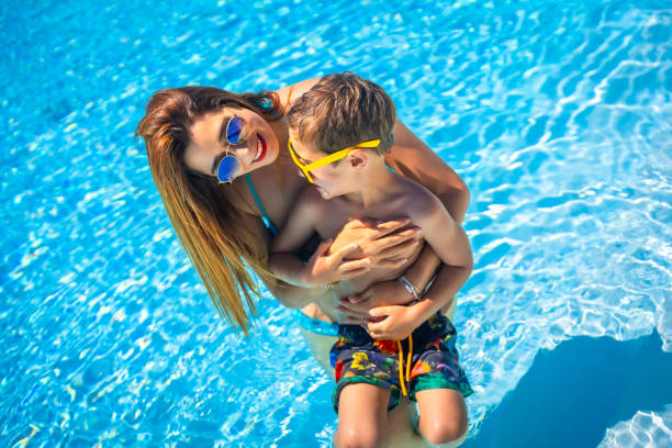 istock Mother and boy in a blue swimming pool together 2159505868