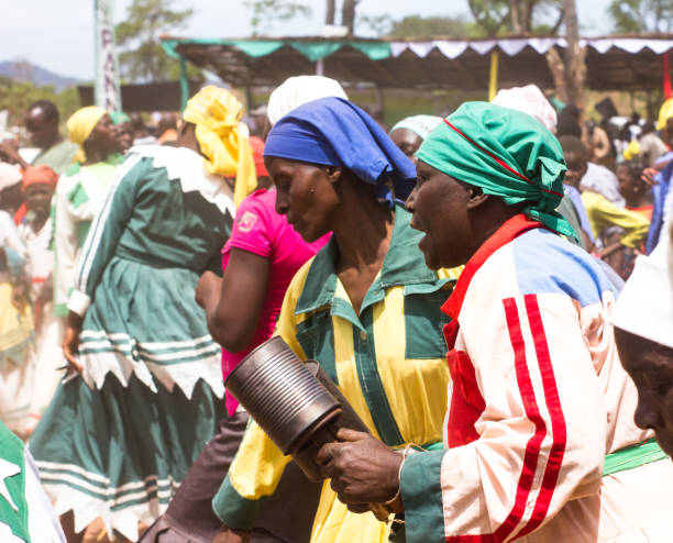 Manica, Mozambique - October 26, 2018: African women playing tin can shakers to a dancing crowd