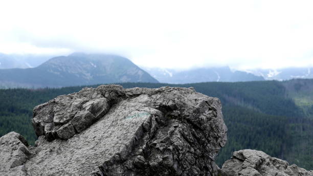 Landscape from a rocky mountain peak under a cloudy sky.