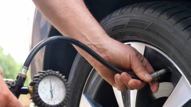 hand checking the air pressure of a tyre while being inflated