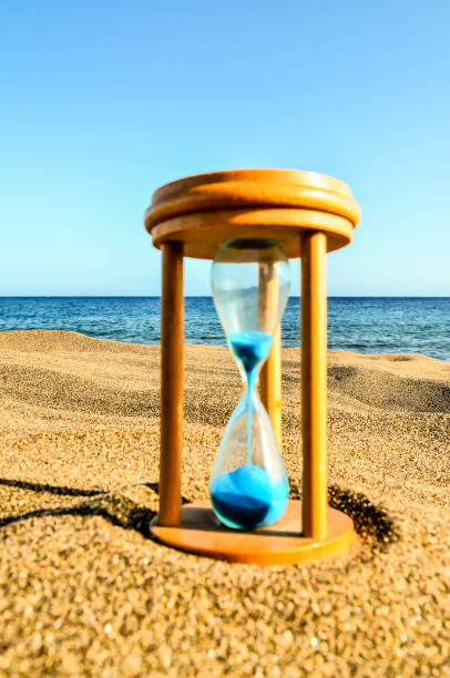 istock Hourglass Clock on the Sand Beach 2159511128