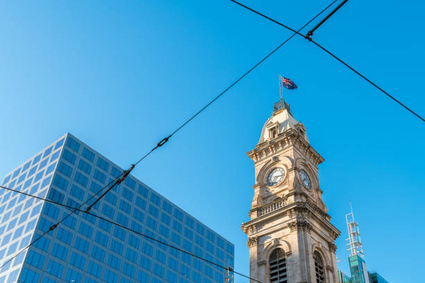 The historic clock tower in Sydney stands proudly alongside sleek modern buildings, creating a striking contrast between the city's rich heritage and contemporary architecture.