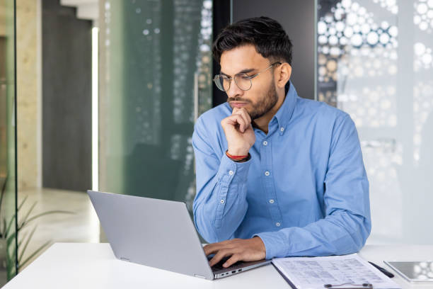 istock Focused young professional working on a laptop in a modern office 2159515069