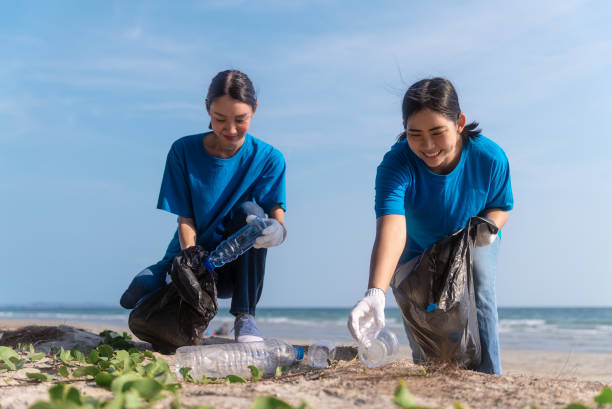 istock Plastic pollution and environmental problem concept. Happy asian diverse group of volunteers with garbage bags wearing blue t-shirt and cleaning plastic on the beach. Volunteers collecting trash. 2159517842