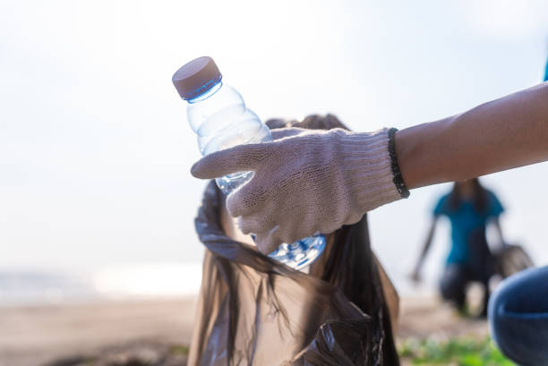 istock Plastic pollution and environmental problem concept. Happy asian diverse group of volunteers with garbage bags wearing blue t-shirt and cleaning plastic on the beach. Volunteers collecting trash. 2159517896