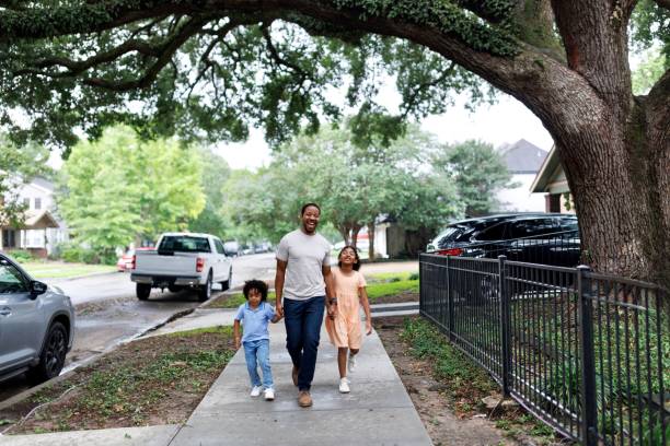 istock Black man walking down the street with his two kids 2159518209