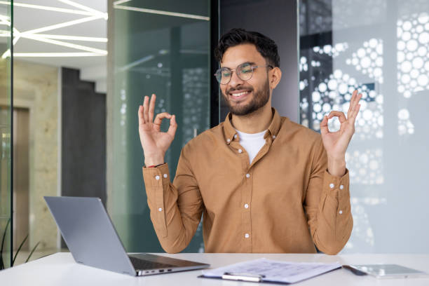 istock Young professional practicing yoga at work desk in modern office 2159518427