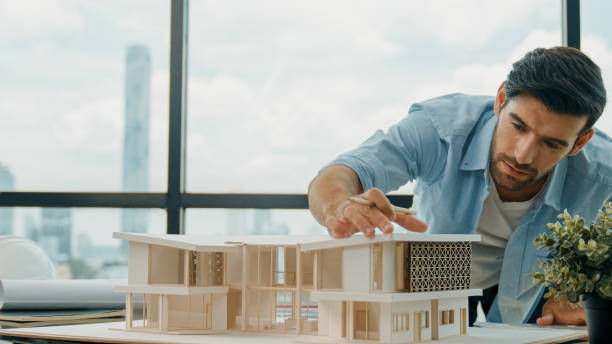istock Closeup of skilled engineer check, inspect, look at house model. Tracery 2159519046