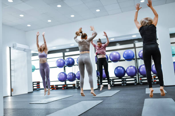 istock Athletic Females Stretching Out Body While Jumping During Workout 2159519182