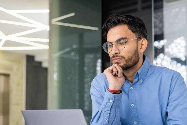 istock Focused young professional working on a laptop in a modern office 2159520614