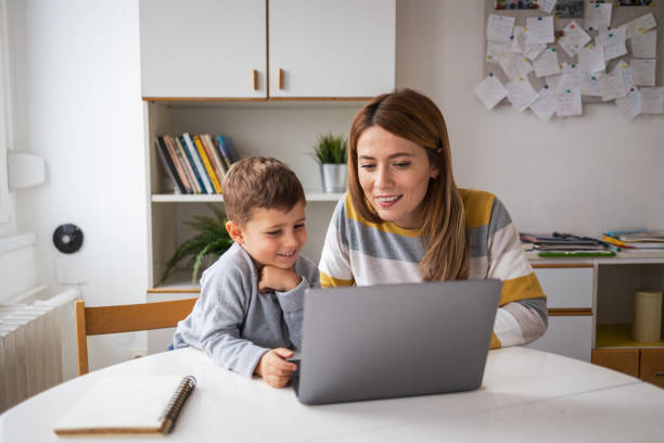 istock Happy mother and son using laptop together at home 2159522079