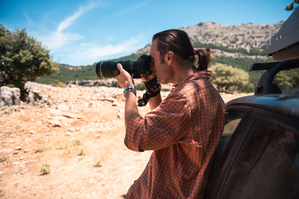 istock Photographer capturing landscape with professional camera outdoors 2159523842