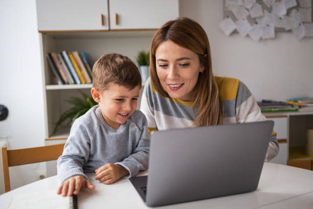 istock Happy mother and son using laptop at desk at home 2159525821